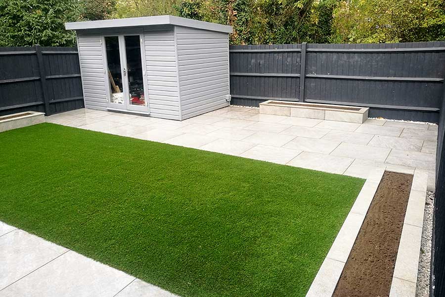A low maintenance garden with porcelain paving and artificial grass by AWBS Landscaping